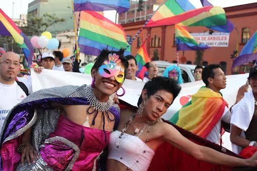 Marchers with rainbow flags at the pride parade in Lima, Peru